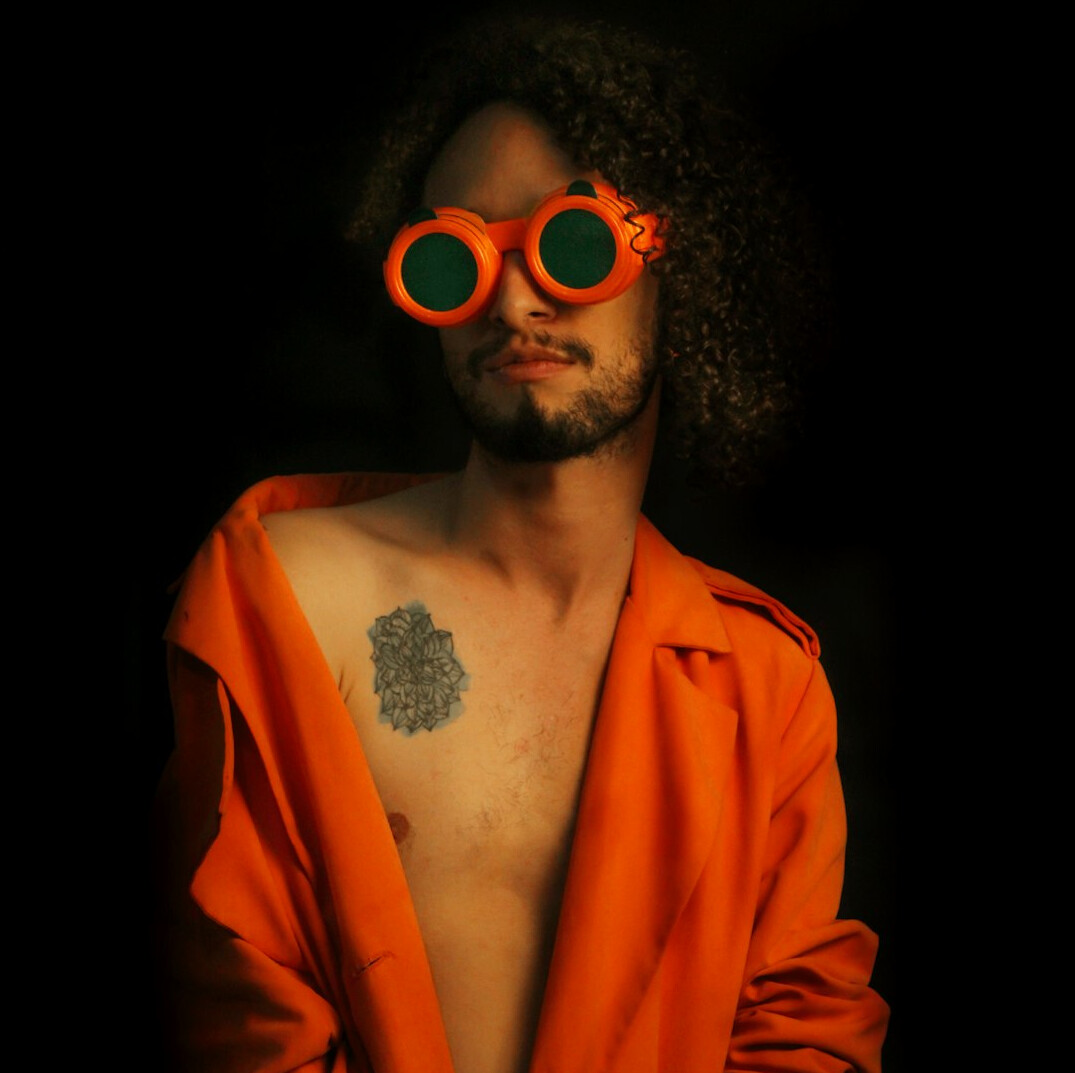 Studio portrait of a Mexican man with a beard and glasses